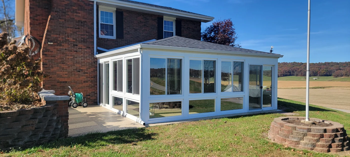 A full-view glass patio enclosure adds comfortable enclosed living space to a Petersburg, IN home.